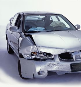 Silver sedan with front end damage and deployed airbags