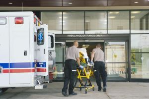 Paramedics taking patient on stretcher from ambulance to hospital