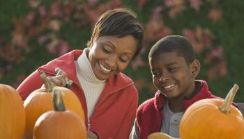 African mother and son carving pumpkins