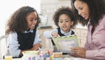 Mixed race mother going over homework with daughters