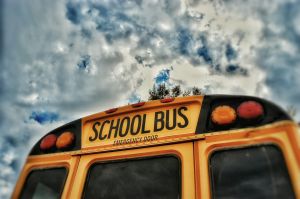 Close-Up High Section Of School Bus Against Clouds