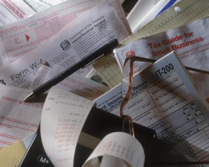 Tax forms, pen and glasses, close-up
