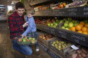 Father and son buying produce in store
