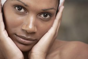 Closeup of an african beauty holding her face in her hands - Skincare & Beauty