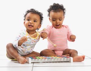 Twin girl and boy playing with xylophone, 18 months