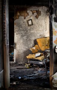 Burnt, Damaged Interior of Home with Destroyed Chair and Books