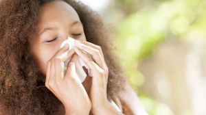 Teenage girl sneezing.