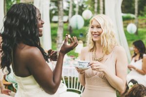 Women having a garden party with dessert table