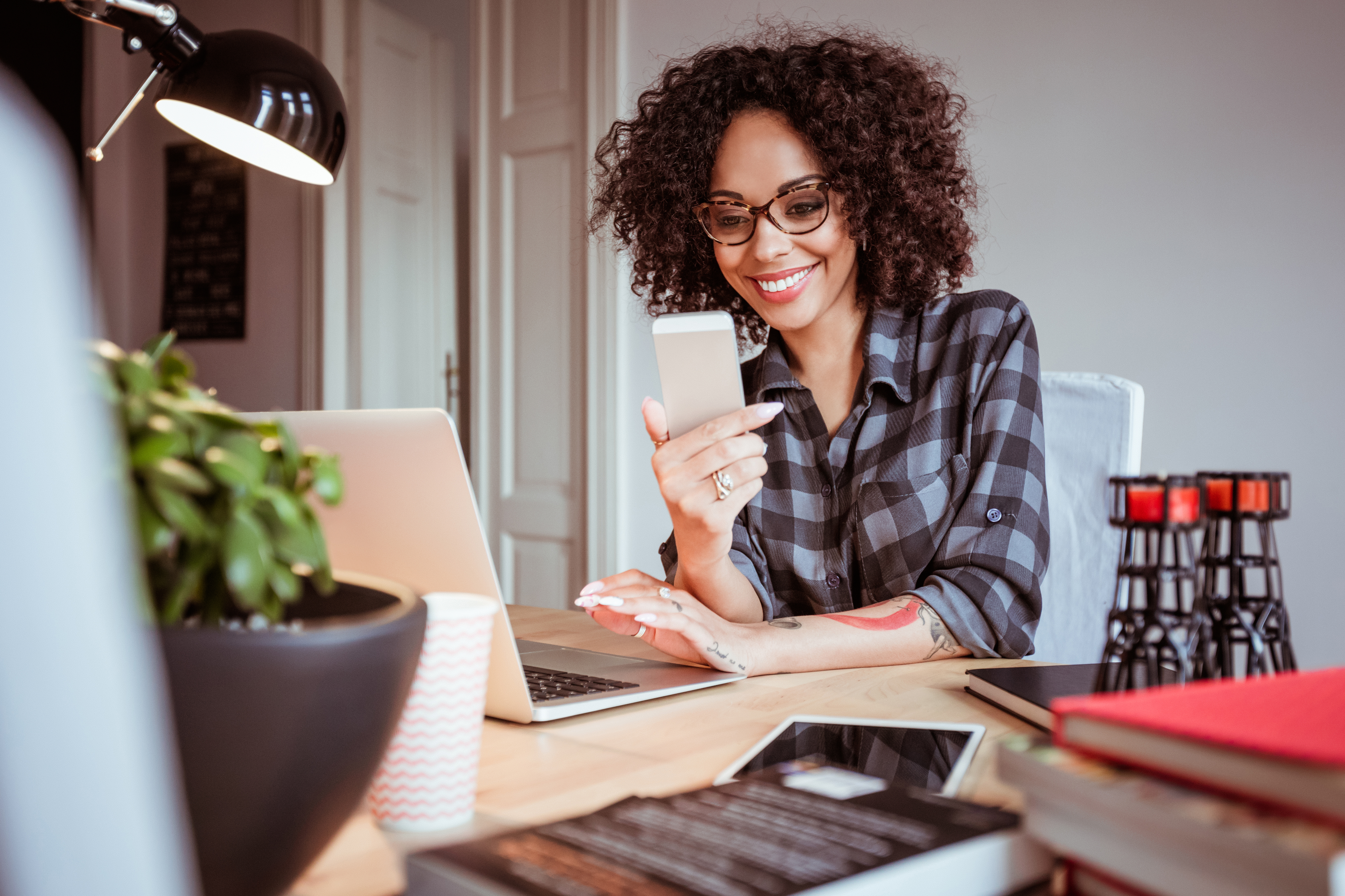 Beautiful young woman at office using mobile phone