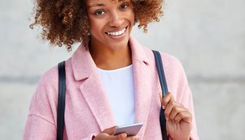 Happy woman text messaging through smart phone