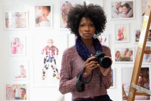 Black photographer holding camera in studio