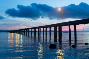 Concrete Pier with Street Lamp over the Sea and Sunrise Sky.