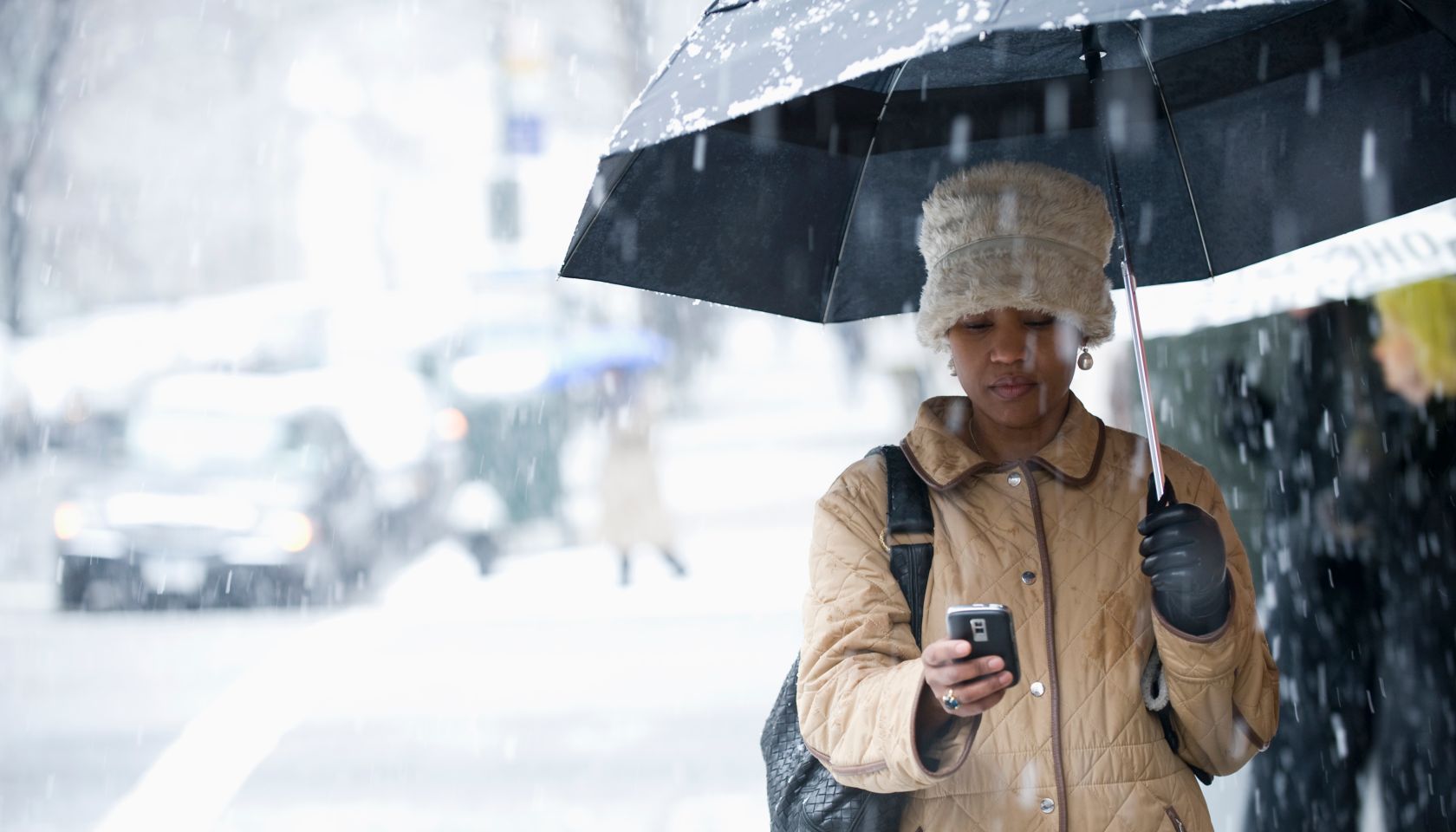 Black woman text messaging in the rain