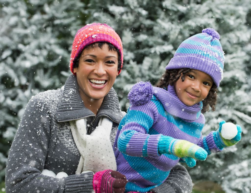 Black mother and daughter having a snowball fight