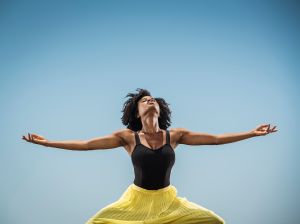 Black woman dancing with arms outstretched