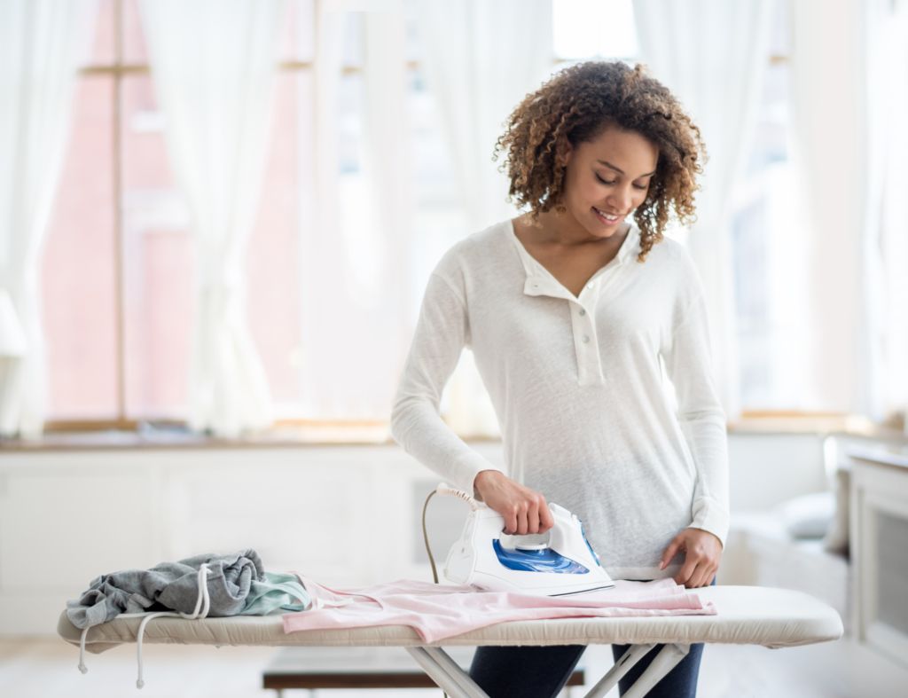 Woman ironing clothes at home