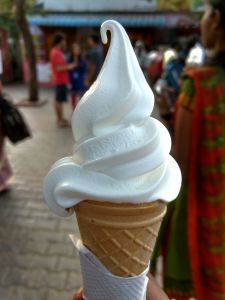 Close-Up Of Ice Cream Cone With People In Background