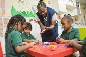 Teacher with students playing with play dough