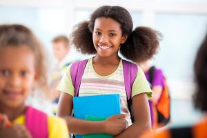 African American schoolgirl smiling and looking at camera.