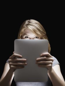 Girl holding glowing digital tablet