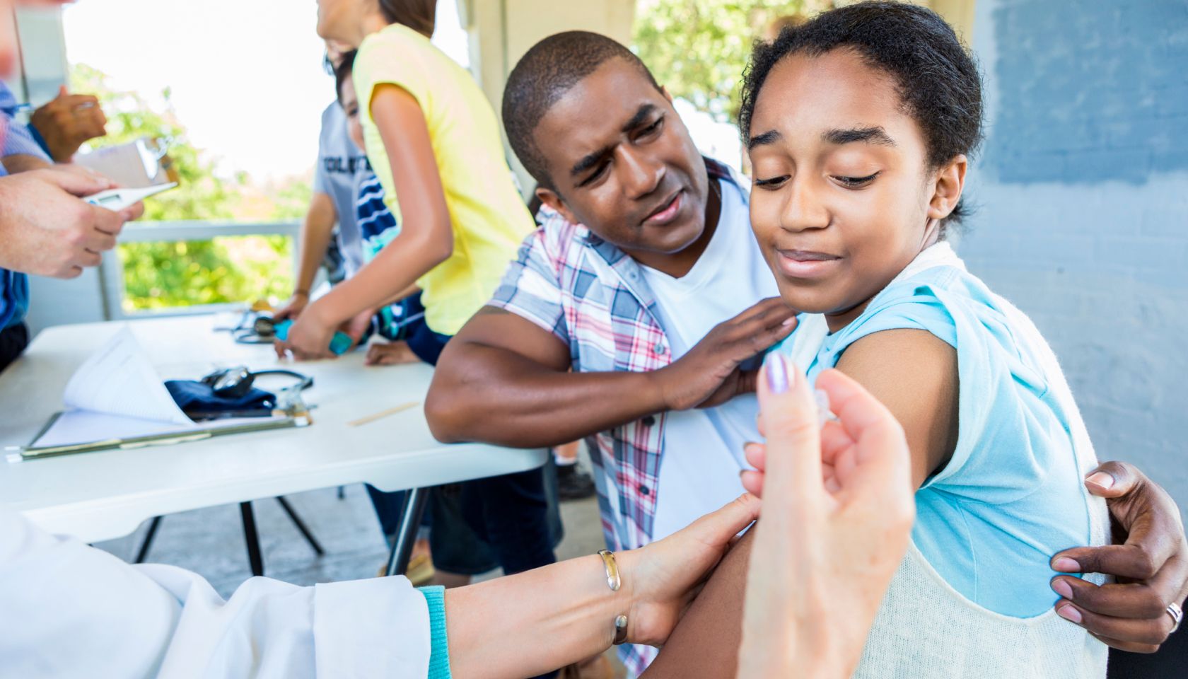 Girl receives flu shot at outdoor free clinic