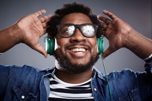 Studio portrait of mid adult man listening to headphones