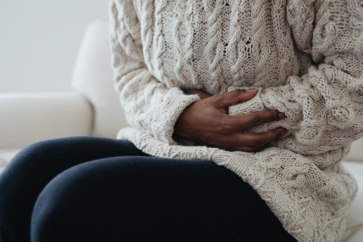 Woman Holds Abdomen in Pain