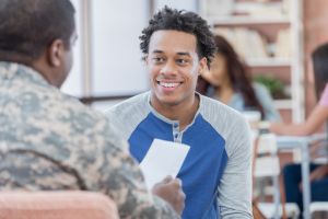 Smiling young man talks with military officer