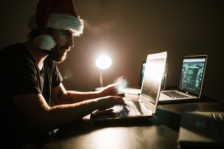 Hacker wearing santa hat stealing money from a credit card