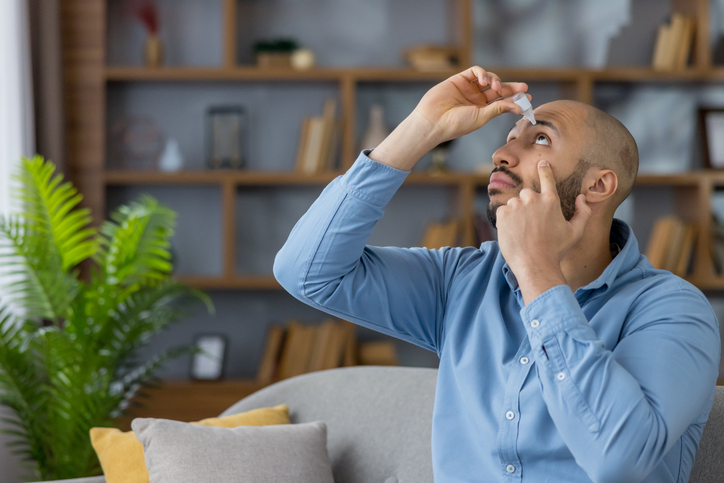 Man applying eye drops for eye care and treatment