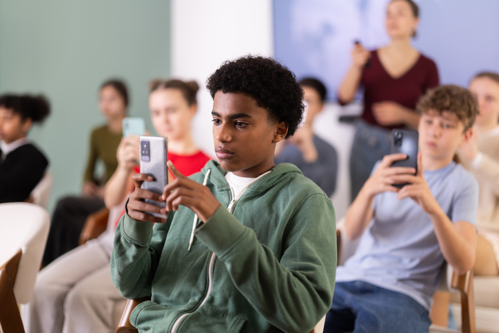Afro American boy scans the qr code of a school lecture