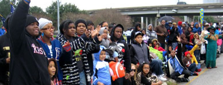 A large crowd of people, mostly children, standing outside a building.