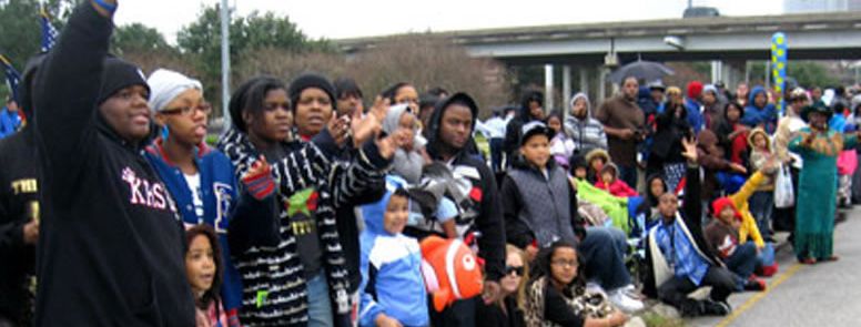 A large crowd of people, mostly children, standing outside a building.