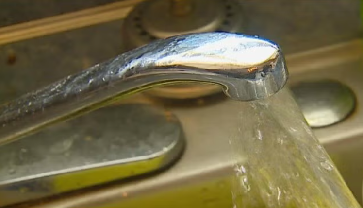 Faucet with running water, close-up view.