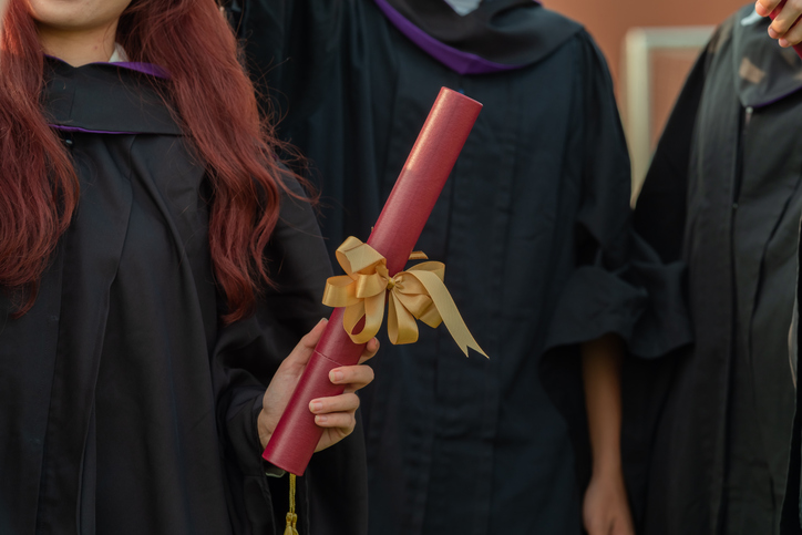 Graduate concept in black robes with diplomas in hands at graduation ceremony stock photo