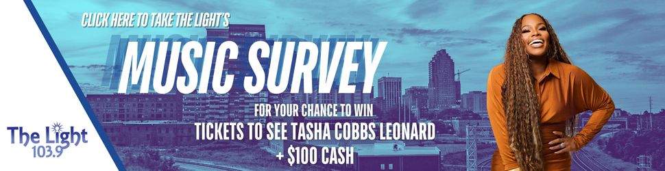 A smiling woman with curly hair wearing an orange jacket stands in front of a city skyline. The text reads "CLICK HERE TO TAKE THE LIGHT'S MUSIC SURVEY FOR YOUR CHANCE TO WIN TICKETS TO SEE TASHA COBBS LEONARD + $100 CASH".
